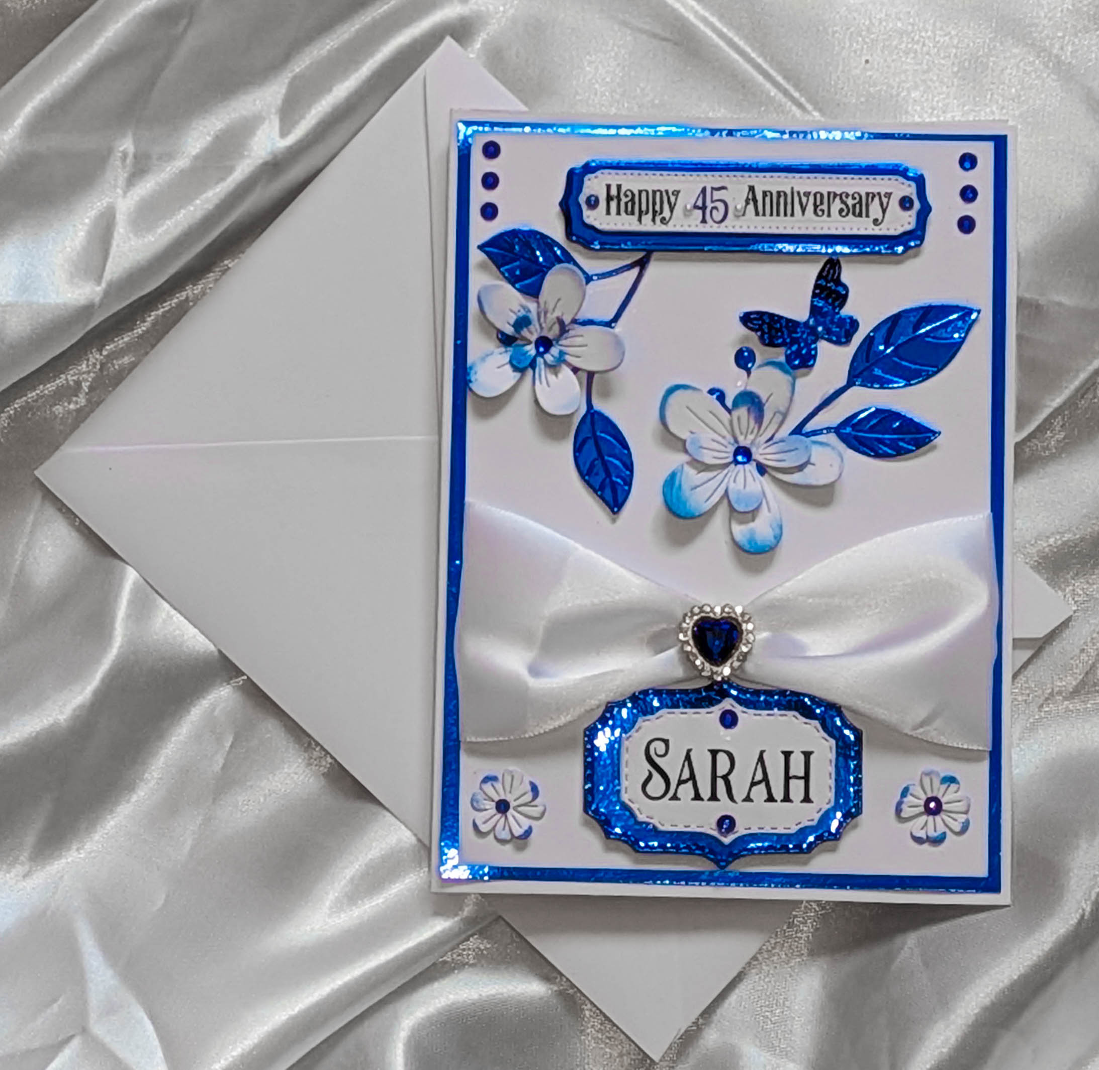 A direct, top-down photograph of the entire personalised handmade card and its matching white envelope.