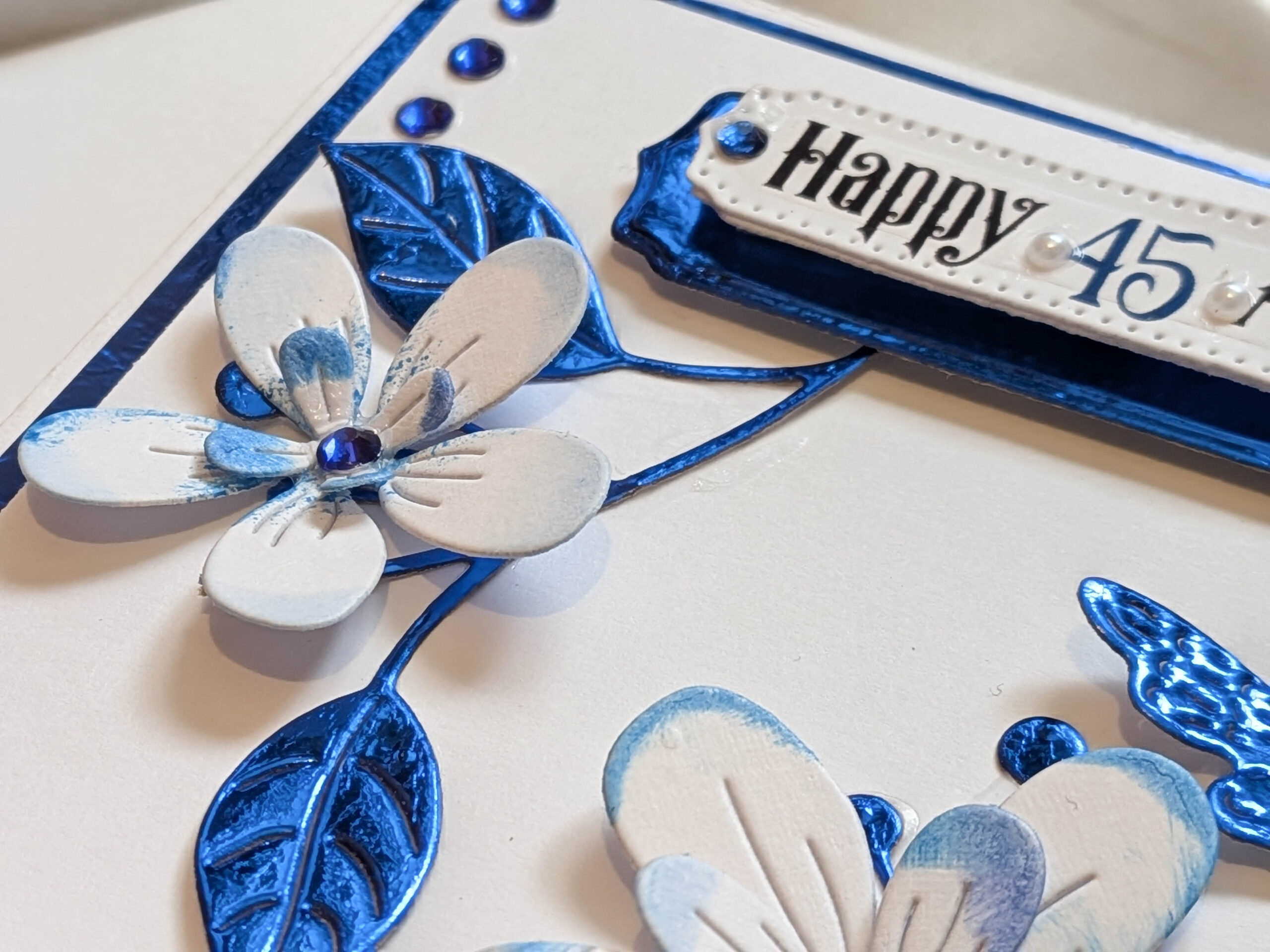 : Angled view of a handmade card showing the custom 'Happy 45th Anniversary' message.