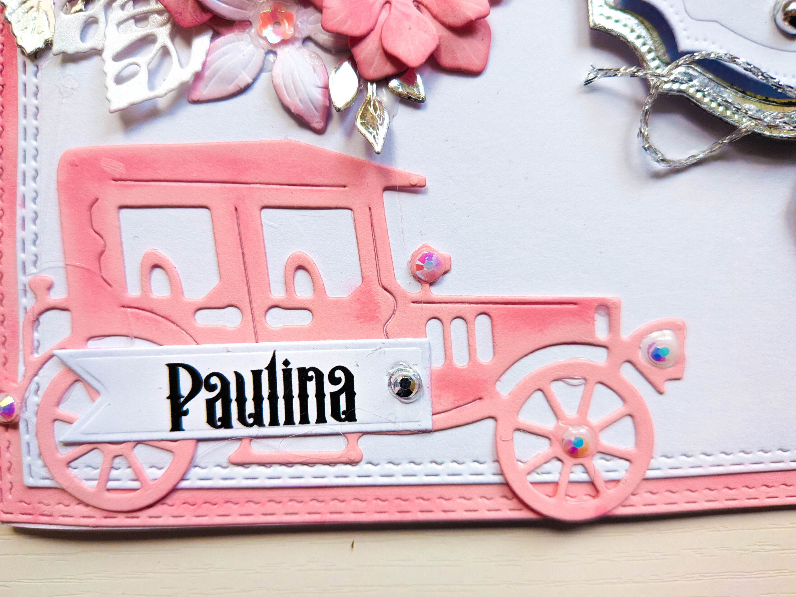 Close-up of pink die-cut vintage car motif with personalised name banner Paulina on stitched cardstock base.