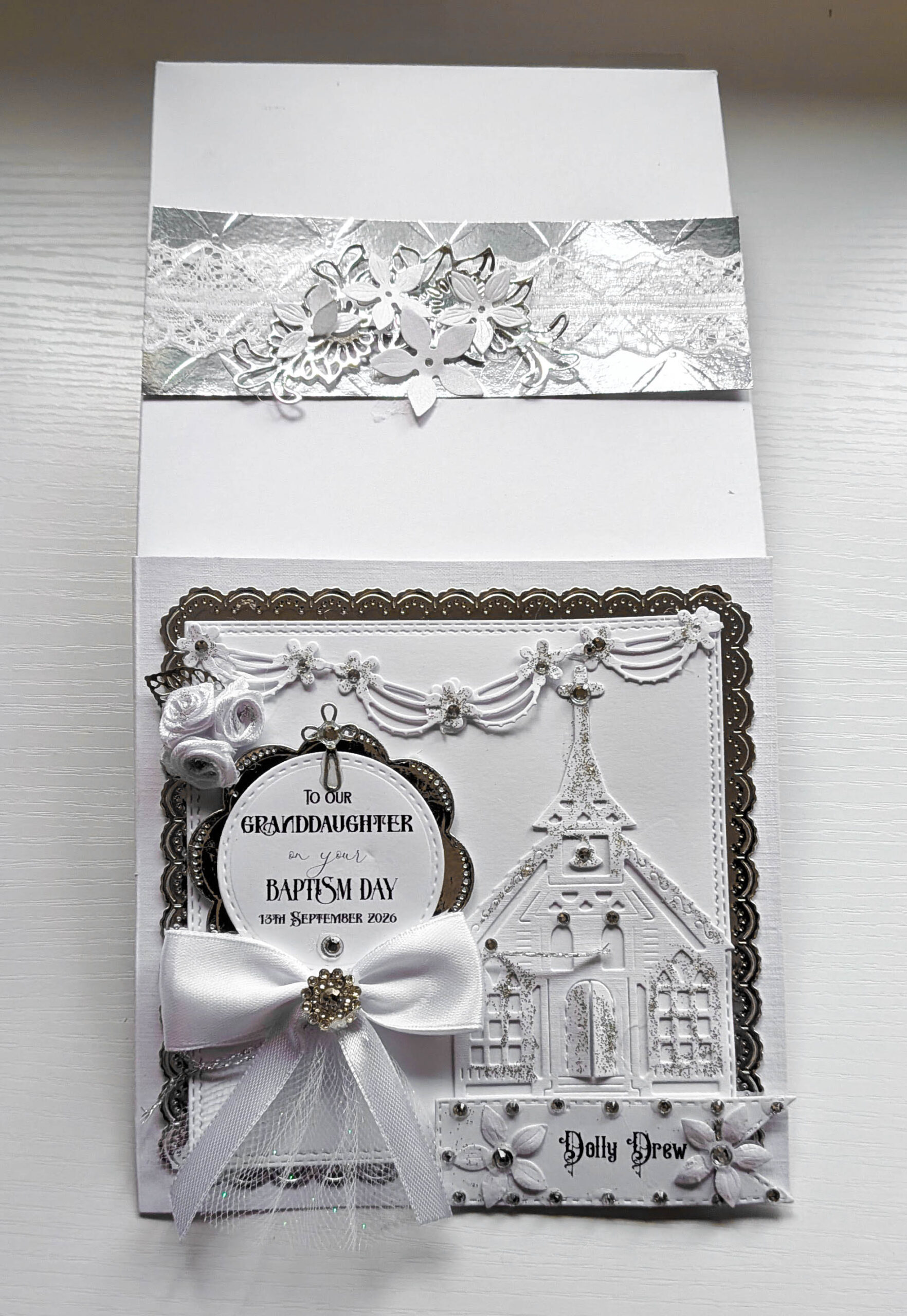 Handmade luxury christening card shown next to decorated gift box with embossed silver band and lace trim.